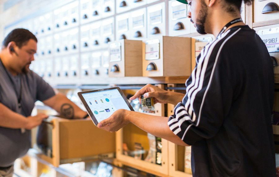 Two people setting up a tablet at a shop counter